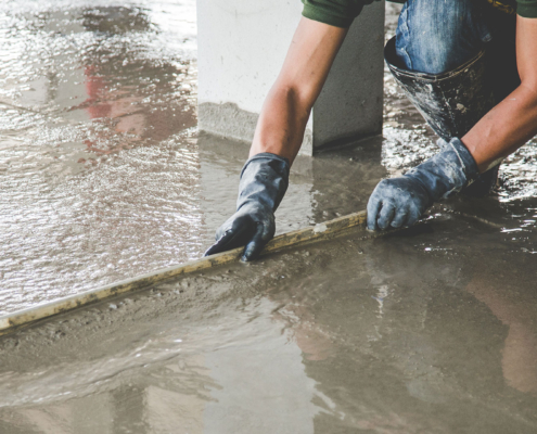 Mason building a screed coat cement cement screed levelled in a commercial property near Swindon