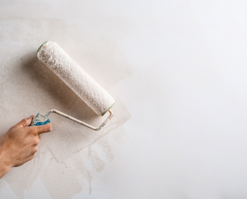 Close up photo of hand painting new plaster