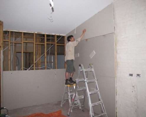 Workman using plasterboard