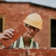 Woman laying bricks on wall